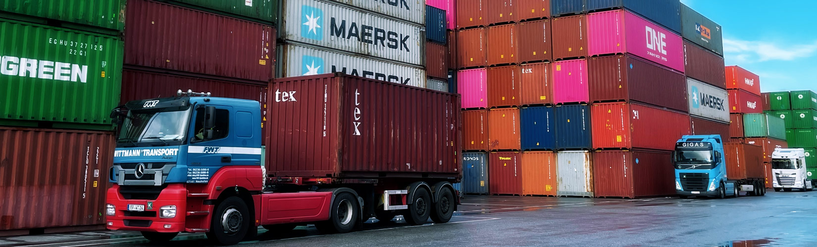 Lkw mit Container beladen mit Containerstapel im Hintergrund