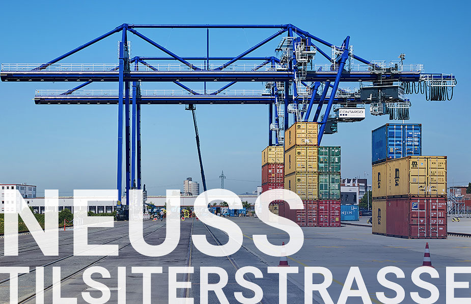 Container Terminal mit blauen Kran im Hintergrund und gestapelten Containern darunter