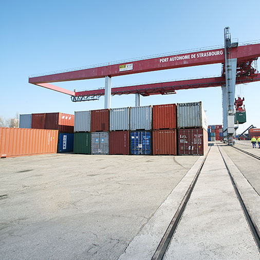 Containerstapel mit Krananlage im Hintergrund