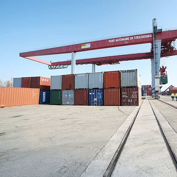 Containerstapel mit Krananlage im Hintergrund