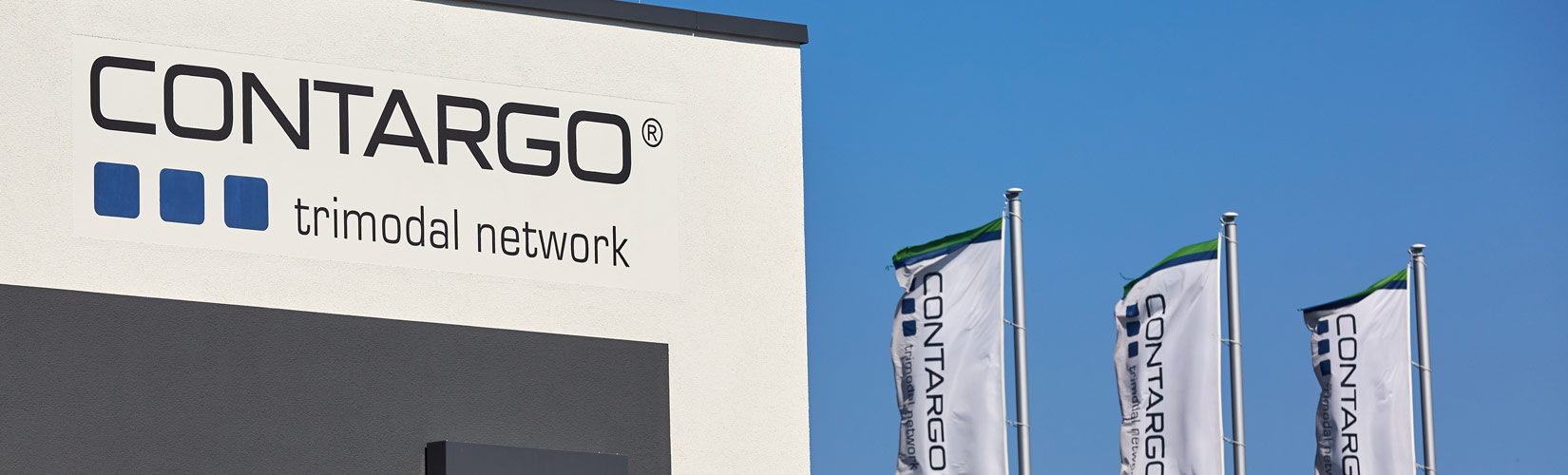 Bürogebäude mit Contargo Logo und drei Flaggen vor blauem Himmel