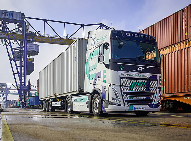 E-LKW auf dem terminal vor Containern und Kran