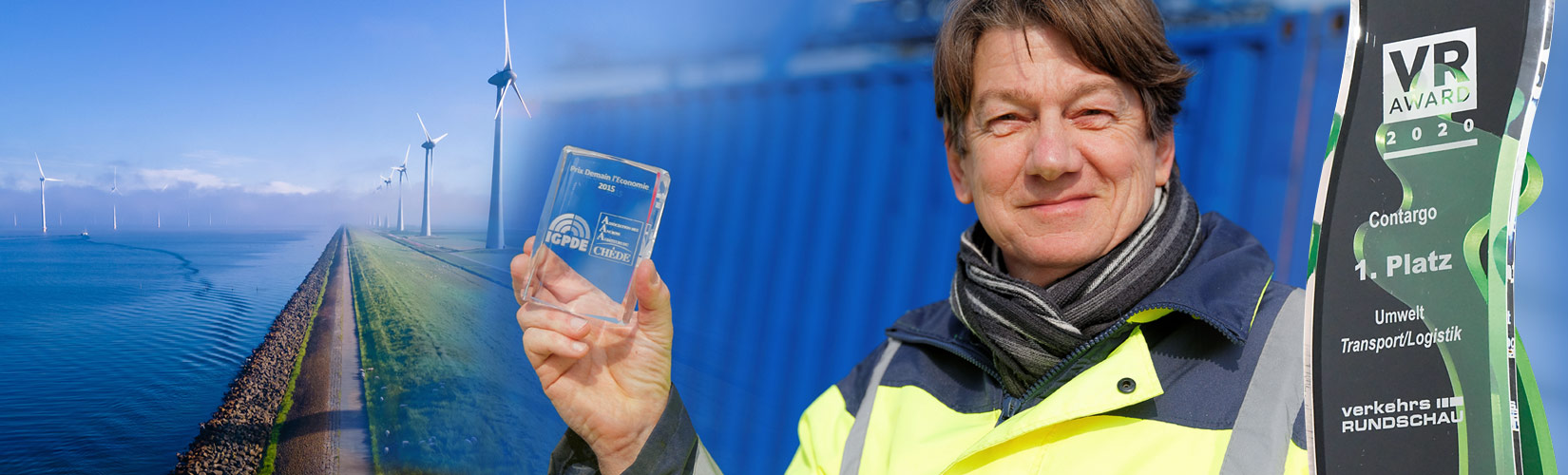 Awards Mitarbeiter hält ein Nachhaltigkeitspreis hoch, links Windräder auf einem Feld