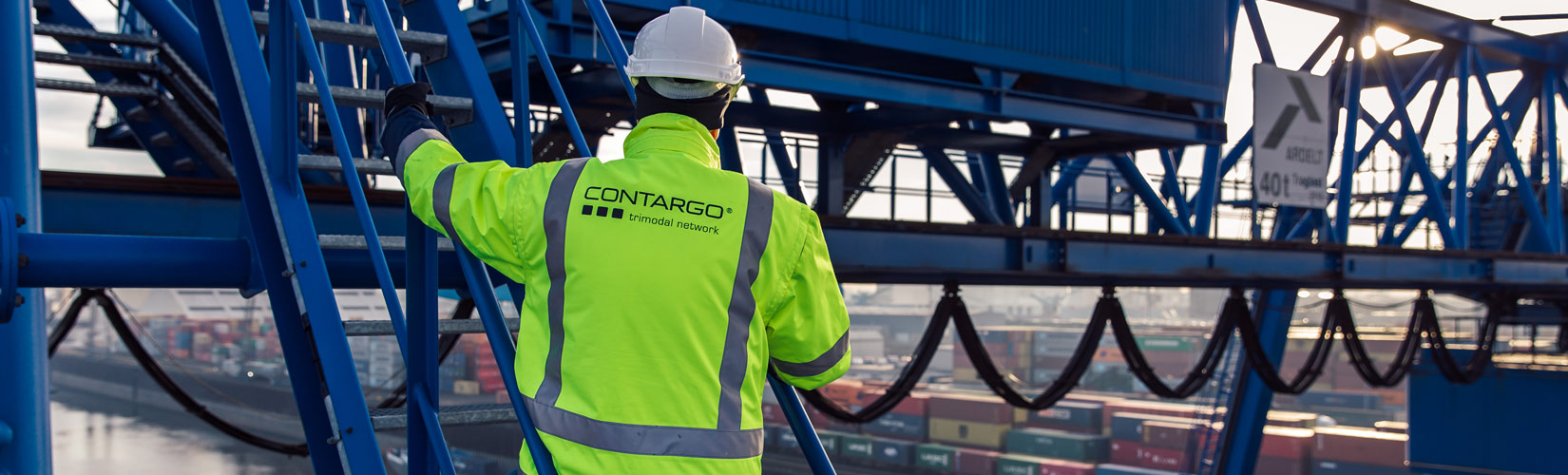 Mitarbeiter Kran Contargo Mitarbeiter mit Warnweste und Helm auf dem Kran mit Blick auf das Terminal