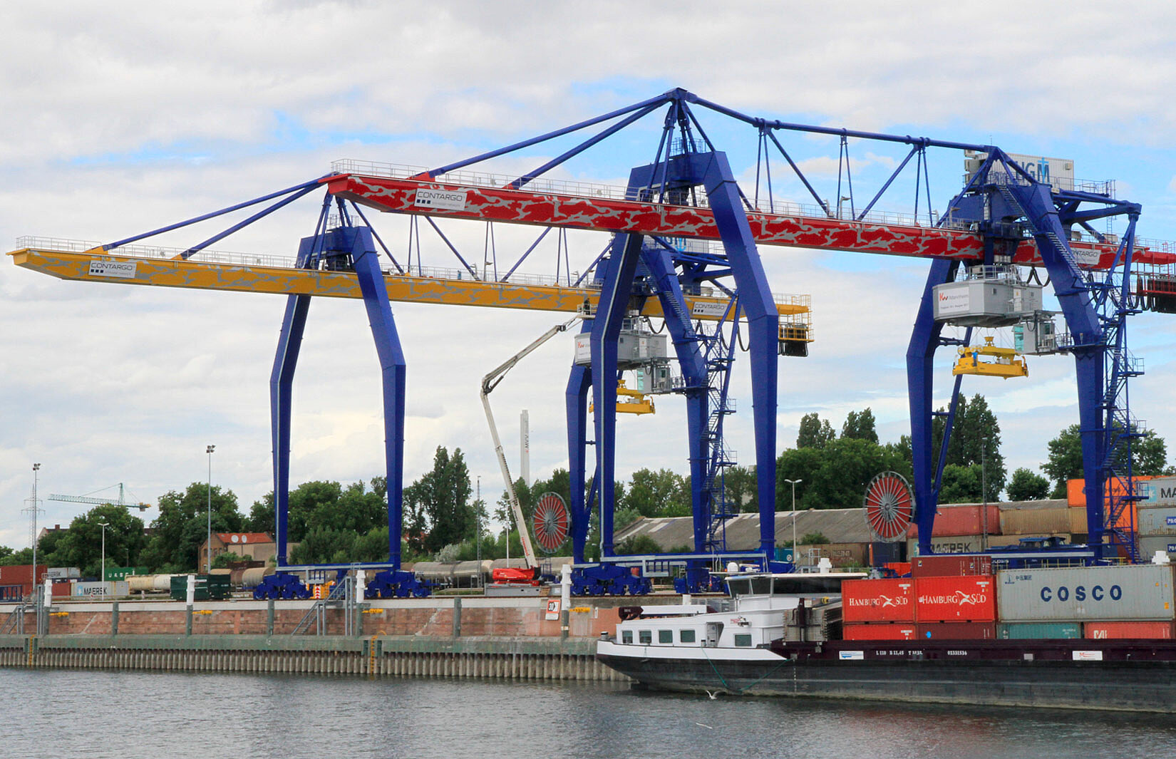 Zwei Neubau Krananlagen in Mannheim mit einem Binnenschiff im Vordergrund