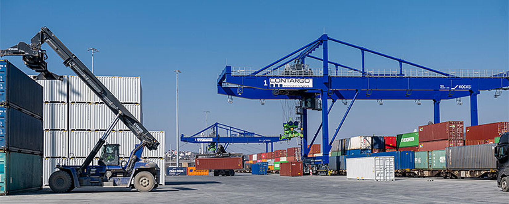 Reachstacker auf dem Container-Terminal Hof mit Krananlagen im Hintergrund