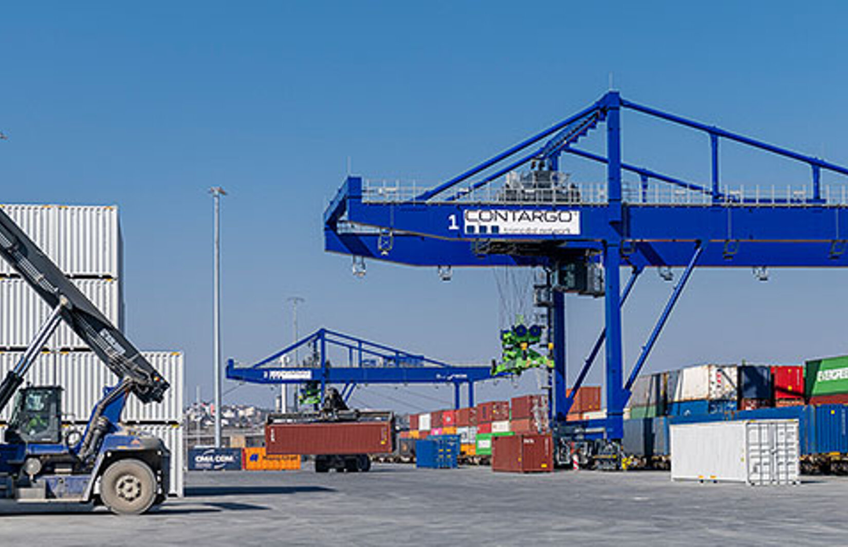 Reachstacker auf dem Container-Terminal Hof mit Krananlagen im Hintergrund