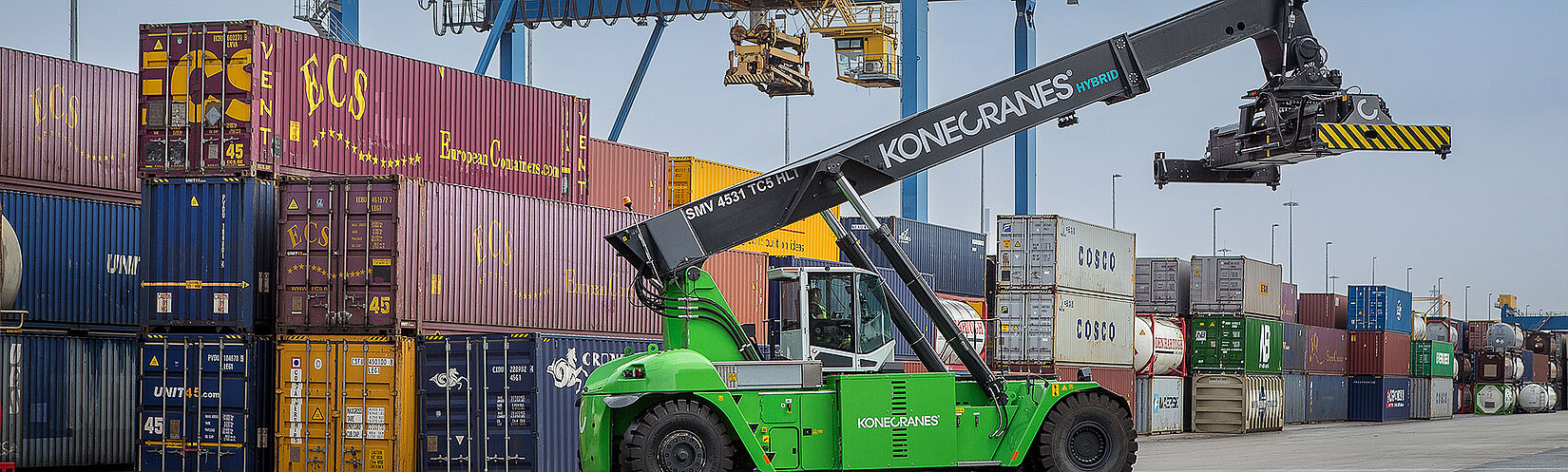 Reachstacker auf dem Container-Terminal in Duisburg mit Krananlagen im Hintergrund