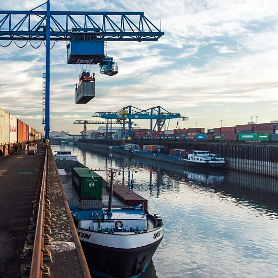 Eine Krananlage entlädt einen Container vom Container-Schiff auf einen Zug