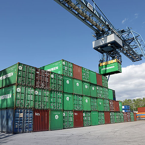 Krananlage hebt Container auf Containerstapel