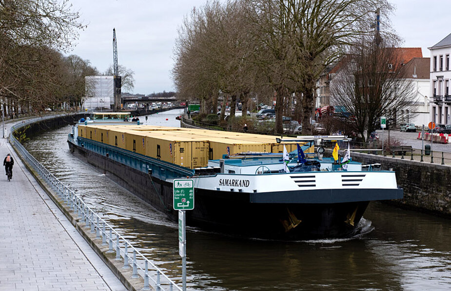 Beladenes Binnenschiff in schmalem Fluss