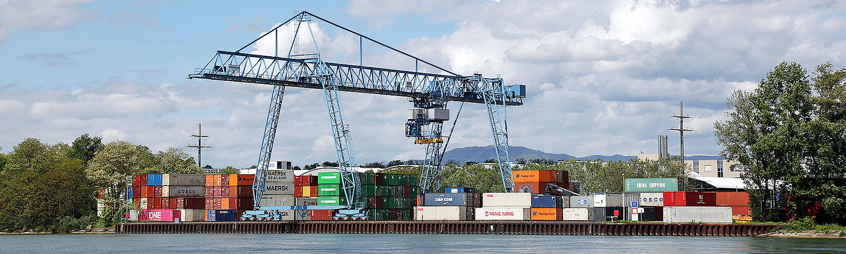 Container-Terminal mit Kran und Fluss im Vordergrund