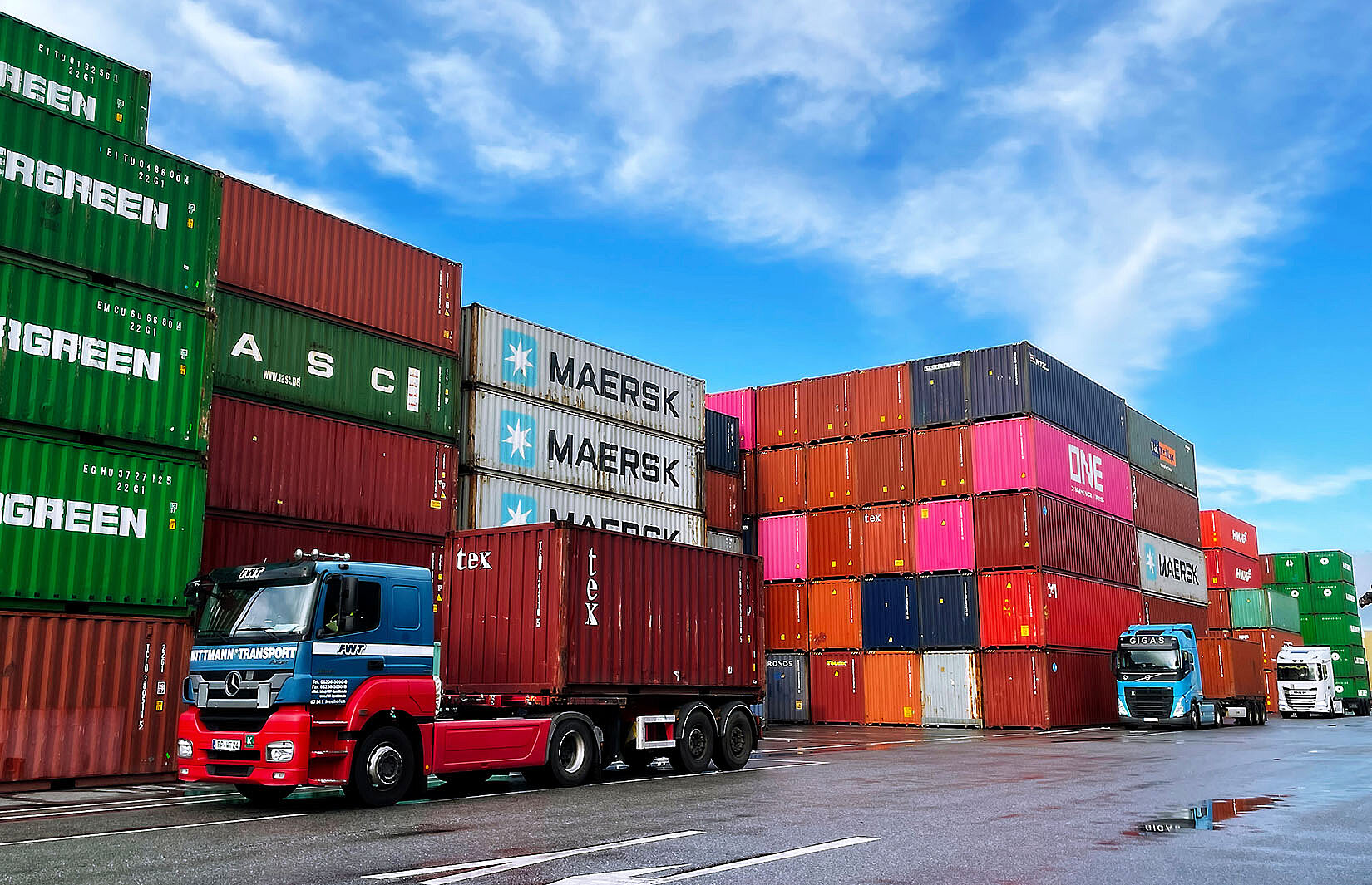 Lkw mit Container beladen vor Containerstapel